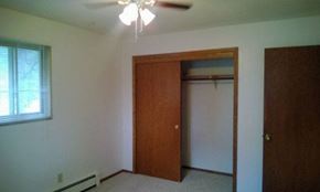 Morris apartment for rent - A room with a brown door and a ceiling fan.